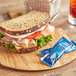 A sandwich on a wooden board with a drink.