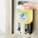 A hand holding a Safeguard foaming hand soap dispenser.