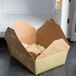 A Fold-Pak Bio-Plus-Earth take-out box of food on a counter.