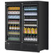 A black Turbo Air refrigerated glass door merchandiser with bottles of liquid and drinks inside.
