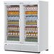 A white Turbo Air refrigerated glass door merchandiser with drinks on shelves.