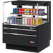 A black Turbo Air horizontal refrigerated open curtain merchandiser with several cans of soda.
