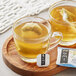 Two cups of Numi Organic Congest Away tea with tea bags on a wooden tray.