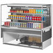 A Turbo Air white drop-in refrigerated display case with cans of soda and cans of different colors.