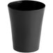 A black plastic shot glass with a white background.