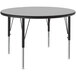 A Correll round activity table with gray granite top and black metal legs.