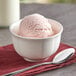 A bowl of Oringer strawberry hard serve ice cream with a spoon.