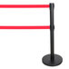 A black Aarco crowd control stanchion with dual red retractable belts.