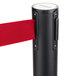 A black Aarco crowd control stanchion with dual red retractable belts.