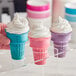 A hand holding a group of JOY assorted color flat bottom ice cream cones.
