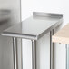 An Advance Tabco stainless steel filler table with legs.