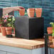 A black cube display filler with pots on top.