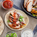 A tortilla with grilled chicken and vegetables on it.