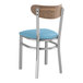 A Lancaster Table & Seating Boomerang Series chair with a blue vinyl seat and vintage wood back on metal bars.