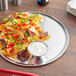 A Choice aluminum tray with nachos and salsa on it.