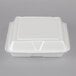A white styrofoam rectangular takeout container with a hinged lid.