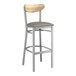 A Lancaster Table & Seating bar stool with a dark gray cushion and wooden back.