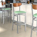 Lancaster Table & Seating bar stools with a seafoam vinyl seat and wood back.