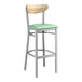 A Lancaster Table & Seating bar stool with a seafoam green seat and driftwood back.