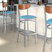 Lancaster Table & Seating bar stools with blue vinyl seats and antique walnut backs.