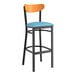 A Lancaster Table & Seating Boomerang bar stool with a blue vinyl seat and black frame.