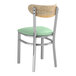 A Lancaster Table & Seating Boomerang chair with a light green vinyl cushion and driftwood back.