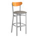 A Lancaster Table & Seating bar stool with a grey vinyl seat and cherry wood back.