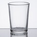 A Sterno Petite clear glass votive holder on a table.
