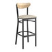 A Lancaster Table & Seating black bar stool with a driftwood back and light gray vinyl seat.