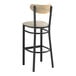 A black bar stool with a light gray cushion and driftwood back.