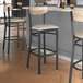 Lancaster Table & Seating Boomerang Series bar stools with driftwood backs and light gray vinyl seats.