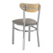 A Lancaster Table & Seating metal chair with a dark gray cushion on the seat and driftwood back.