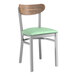 A Lancaster Table & Seating Boomerang chair with a seafoam green vinyl seat and vintage wood back.