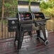A Pit Boss Navigator combo grill on a deck with food cooking on it.