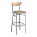 A Lancaster Table & Seating bar stool with a taupe vinyl seat and driftwood back on metal legs.