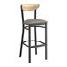 A Lancaster Table & Seating Boomerang bar stool with a wooden back and cushioned seat.