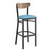 A Lancaster Table & Seating Boomerang bar stool with a blue seat and black frame.