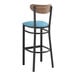 A Lancaster Table & Seating black bar stool with blue vinyl seat and vintage wood back.