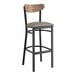 A Lancaster Table & Seating black bar stool with a gray vinyl seat and wood back.