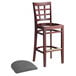A Lancaster Table & Seating mahogany wood bar stool with a detached dark gray vinyl seat.