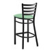 A Lancaster Table & Seating black ladder back bar stool with a seafoam green padded seat.