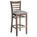 A Lancaster Table & Seating wood bar stool with light gray vinyl seat.