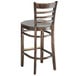 A Lancaster Table & Seating wooden bar stool with a light grey cushion detached.