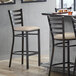 A Lancaster Table & Seating distressed copper ladder back bar stool with a light gray cushion on the seat.