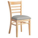 A Lancaster Table & Seating wooden chair with a light grey cushion.