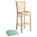 A Lancaster Table & Seating wooden bar stool with a seafoam vinyl cushion on a white background.