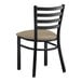 A Lancaster Table & Seating black metal ladder back chair with a taupe vinyl padded seat.
