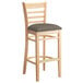 A Lancaster Table & Seating wooden bar stool with a taupe cushion on the seat.