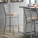 A Lancaster Table & Seating clear coat finish ladder back bar stool with a light gray vinyl padded seat.