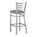 A Lancaster Table & Seating metal ladder back bar stool with a dark gray vinyl padded seat.
